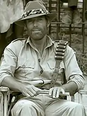 Richard Chamberlain sitting on a film set