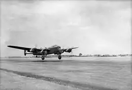 Four-engined, twin-finned military aircraft taking off
