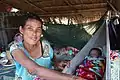 Baby sleeps in a hammock in a hut in Laos.