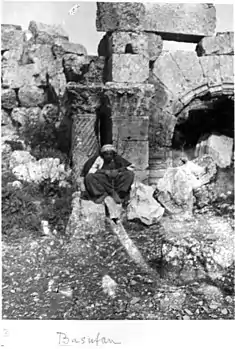 Kurdish man in front of the church apse. Twisted column, Corinthian capital.