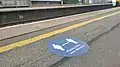 An outdoor vinyl sticker promoting social distancing on platform 1.