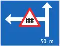 4.55 Announcement of a branching road with a dangerous situation or restrictions (here: side road to the left 50&nbsp;m ahead with the warning of the presence of a gated level crossing right after the turn)