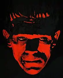 Painting of the face of Frankenstein's monster, illuminated in red and surrounded by darkness