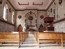 dark wood pews, altar and private royal pew carved with floral motifs and hung with red satin
