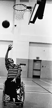 Wheelchair basketball player-coach shoots a layup