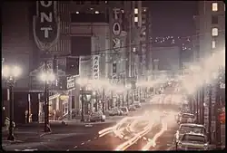 A time lapse photo of a street in portland at night. It shows the Fox Theatre and surrounding buildings with their marquee lighiting off.