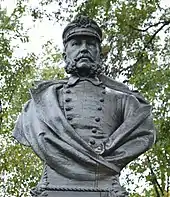 Photo shows a bronze bust of a man in a naval uniform with a cap.