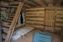 Photograph showing single bedding on a pallet on a dirt floor