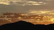 Sunrise over the summit of Mount Nardi from the south, showing the radio and digital television transmission towers