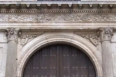 In the spandrels of the arch of entrance there are two ornamental figurines that represent some boys or sand devils that hold some fruits.