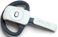 Xbox 360 Wireless Headset, a single-ear headset that combines an earphone and microphone for voice chat over the Xbox Live online service. The headset connects wirelessly with the Xbox console, and features a dark grey ear loop to hold it in place; the microphone boom extends forward a short distance towards the wearer's mouth. On the outside of the headset are three buttons to control volume and power, arranged in a circle.