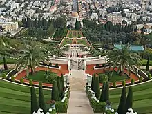 Elaborate gardens with several gates and a walkway leading to a domed building in the distance