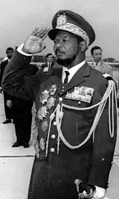 Jean-Bédel Bokassa stands saluting in military uniform