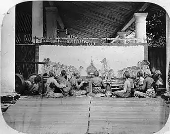 Wayang kulit (shadow puppet show) accompanied by a gamelan ensemble in Java, circa 1870.