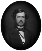Black-and-white photograph of a young man with a mustache