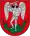 A coat of arms depicting an angel in full body armour and wings outspread while standing on a green dragon with a twisted tail