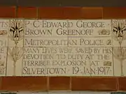 A tablet formed of five tiles of varying sizes, bordered by yellow and blue flowers in an art nouveau style