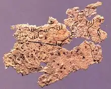 Fragment of ancient Chinese paper map with features in black ink, found on the chest of the occupant of Tomb 5 of Fangmatan, Gansu in China in 1986, from early Western Han, 2nd century BC, 5.6&nbsp;cm ×&nbsp;2.6&nbsp;cm (2.2&nbsp;in ×&nbsp;1.0&nbsp;in).