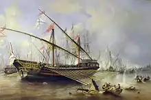 A large galley in shallow waters with oars out and its deck covered with soldiers. More galleys are visible in background which is partially obscured by white smoke.