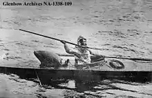 "black and white image of an Inuit hunter seated in a kayak holding a harpoon"