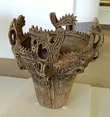 Ornately detailed clay pot in a museum