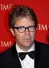 A spectacled Jonathan Franzen  is pictured in a tuxedo on a Time magazine red carpet. His short hair is somewhat untidy.