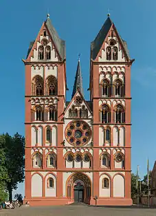 Limburg Cathedral, Germany. The facade, c. 1200, with polychrome plaster, follows the paired-tower model found at several Rhineland churches. The rose window has plate tracery and the spires are Rhenish helms.