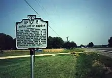 Madison's birthplace. It is on the west side of US 301 in front of Emmanuel Episcopal Church and is just north of the Rappahannock River bridge. Belle Grove plantation house, the actual birthplace, was located 400 yards east and is no longer in existence