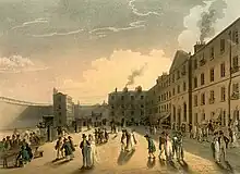 Painting showing a yard inside a prison. The yard is surrounded on all sides by walls. Some people are walking around others are sitting at tables. In general, the people are dwarfed by the buildings and the color scheme is yellow and almond.