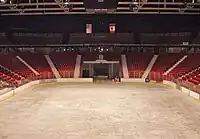 An empty arena with the sheet of ice and the score board