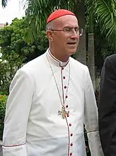 Tarcisio Cardinal Bertone in dress for hot tropical countries (white cassock with scarlet piping and buttons).