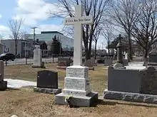 A white marble cross on a cemetery