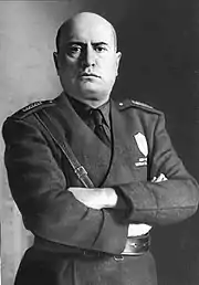 official portrait of Mussolini in uniform with crossed arms