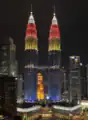 The Petronas Towers illuminated at night with the colours of the national flag of Malaysia