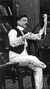 Dadasaheb Phalke, examining a strip of film
