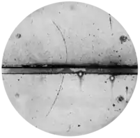 Curved arc shows a cloud chamber trajectory of a positron.