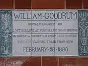 A tablet formed of six standard sized tiles, bordered by green flowers in the style of the Arts and Crafts movement