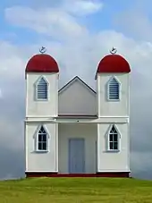 Simple white building with two red domed towers