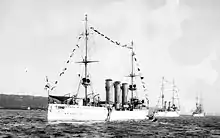 Three large ships painted white in a line close to the waterfront