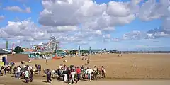 Panoramic image of the beach crowded with people.