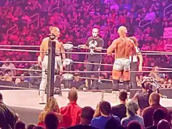 A color photograph of a group of people in a wrestling ring