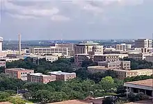 a skyline view of the Texas A&M campus. Dozens of buildings are visible including one that is domed