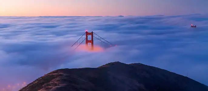 A view of the Golden Gate Bridge from the Marin Headlands on a foggy morning at sunrise