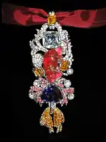 Detailed view of the recreated great Golden Fleece of king Louis XV of France. Below the 107 carats (21.4&nbsp;g; 0.75&nbsp;oz) spinel Côte de Bretagne hangs the French Blue diamond and the fleece itself, set with hundreds of yellow diamond replicas