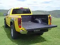 Flat sided pickup truck showing wheel well intrusion into bed