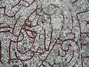 A female figure bearing a horn on runestone U 1163.