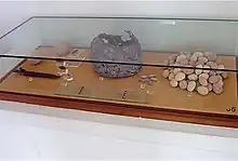 a glass display case containing stones and a pot